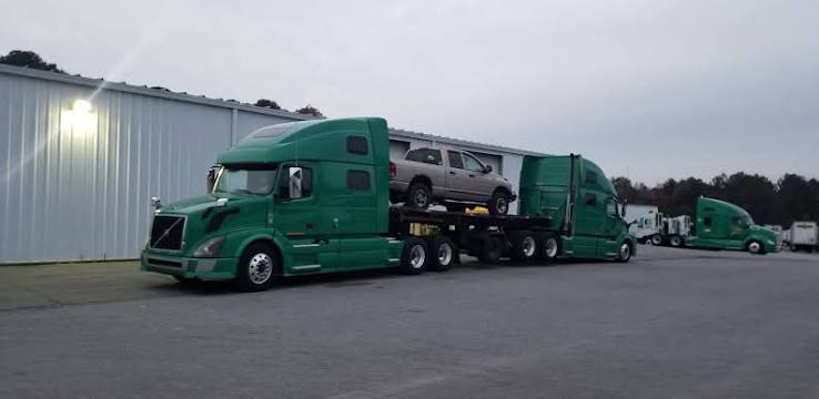 Green truck hauling pickup